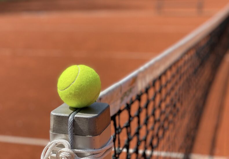 Jucător de tenis analizând tactic un punct în timpul unui meci de simplu.